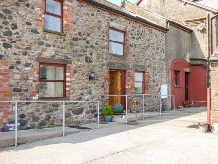Exterior view of a stone house with windows plants and a handrail at Muncaster View in Carleton near Ravenglass