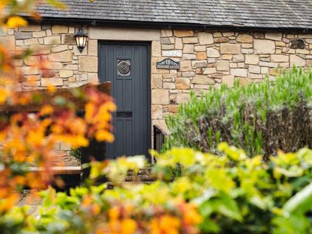 A door with a light fixture and sign at Blueberry Cottage in Akeld near Wooler