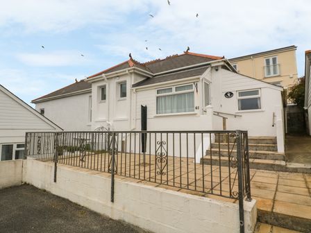 White house with tiled patio and metal railing at Treleigh in Hayle near St Ives