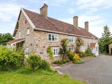 Stone cottage with tiled roof and multiple chimneys with garden and driveway at Whitehall Farm Cottage in Honiton