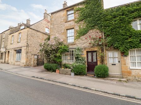 Stone houses with plants and ivy along a street at Benfield in Stow on the Wold