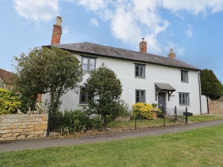A house with trees and garden at Elmhurst Cottage in Lower Quinton