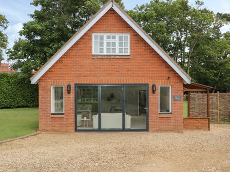 A brick house with large glass doors and two windows at Thames Reach in Wallingford
