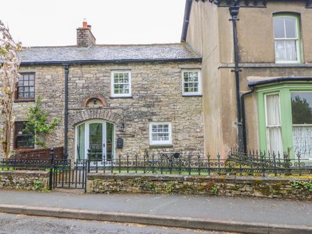 Stone cottage with black iron fence and small garden area at Linden Cottage in Ravenstonedale Nr Kirby Stephen