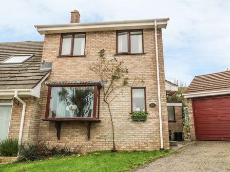 A brick house with windows and a garage with a red door at Phenests in Falmouth