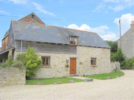 A stone and wood house with a tiled roof and grass in front at The Courthouse in Sutton Poyntz