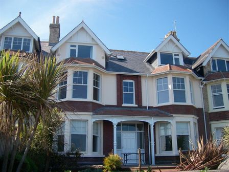 A front view of a large brick and white house with bay windows and a small porch at Dream View in Greenhill