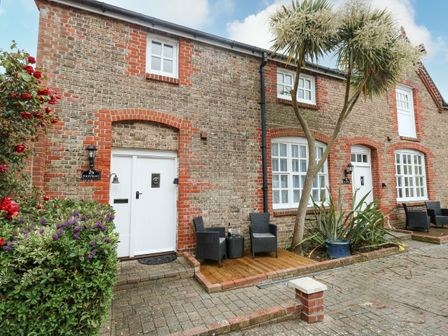 The exterior of a brick house with white doors and windows outdoor chairs and plants at Footprint Brewers Quay Harbour