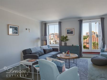 A sitting room with sofas chairs and a round coffee table at Marina Vista in Weymouth