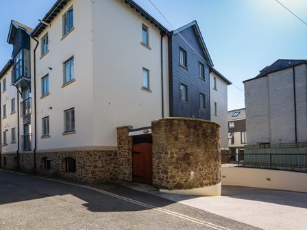 A street view of a three story building with stone base and cream walls at 12 Dartmouth House in Dartmouth