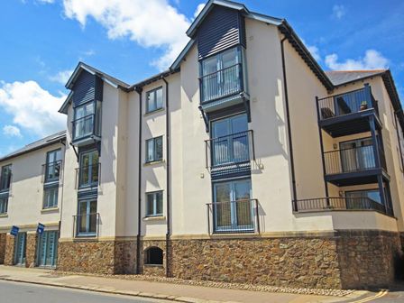Exterior view of a modern apartment building with stone base and balconies at 15 Dartmouth House in Dartmouth