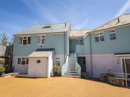 Exterior front view of a two-story house with stairs leading to an upper entrance at 3 Church Hill House in Salcombe