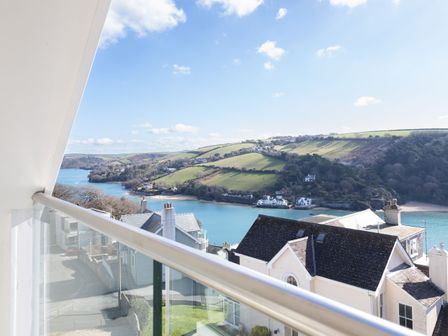 A view of a river and hills with houses in the foreground from a balcony at 4 Blue View in Salcombe