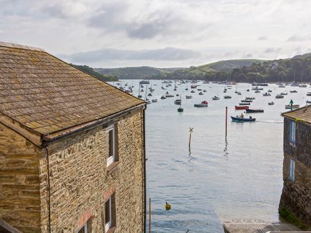 A view of boats on water between two stone buildings overlooking a harbor at 8b Fore Street Salcombe
