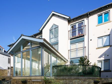 A multi-story building with large windows and a glass entrance at 9 Dartmouth House in Dartmouth