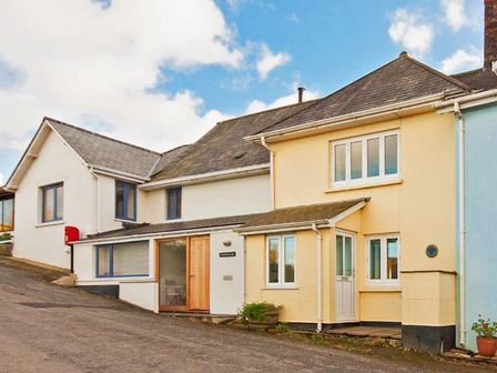 Row of connected houses with sloped roofs and small windows at Bow Cottage East Portlemouth