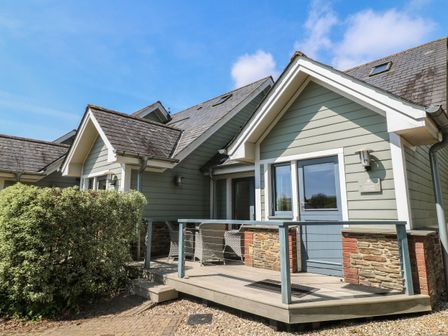 A house with a deck and bushes at 6 Court Cottage, Hillfield Village
