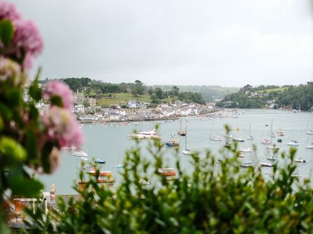 A harbor with boats on water and houses on hills at Postcard Lodge in Polruan