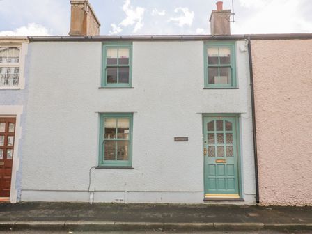 A small terrace house with green windows and door on a street at Bryn Haf New Street in Beaumaris
