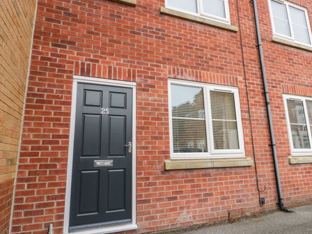 A front door numbered 25 and windows on a red brick building at Valiant House in Scarborough