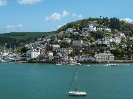 A waterfront village with houses on a hillside and boats in the water at 18 Southtown in Dartmouth