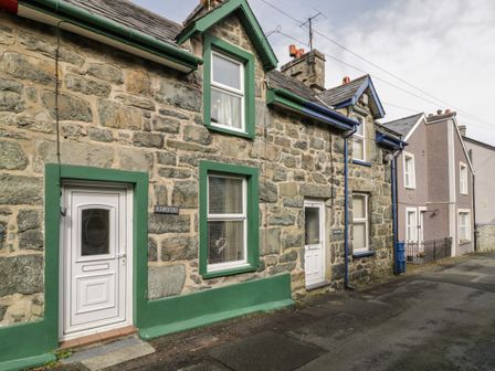 Stone houses with white doors and green and blue window frames on a street at Edrydd in Harlech