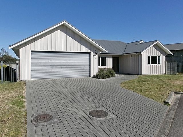 A single story house with a double garage and paved driveway at Lochaber Lodge - Acacia Bay Holiday Home in Acacia Bay