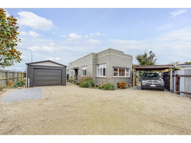 An outdoor view of a house with a garage and a carport at Ezy Walk - Blenheim Holiday Home, Blenheim