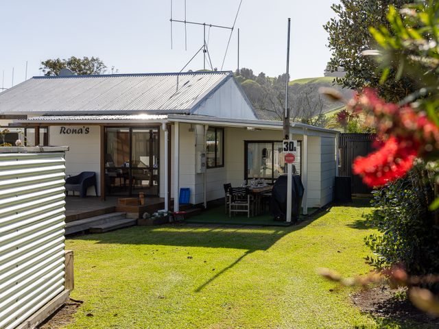 A house with a patio and garden at Ronas - Whiritoa Beach Bach Whiritoa Beach