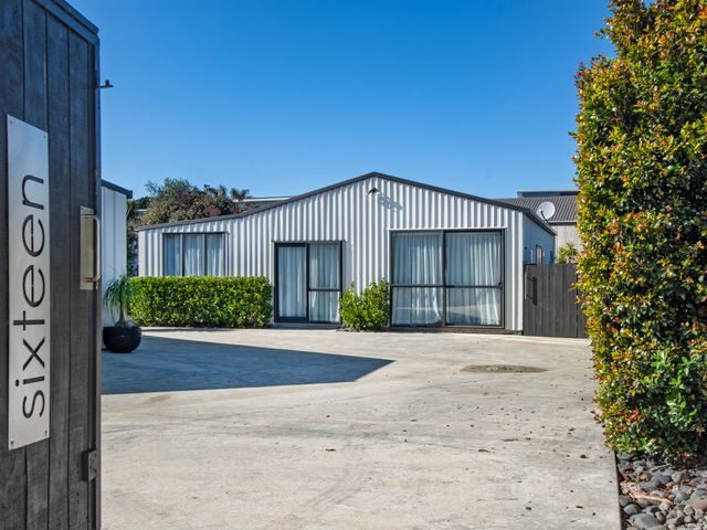 An outdoor area with a building and signage at Sunnyside Spa Retreat - Mangawhai Heads