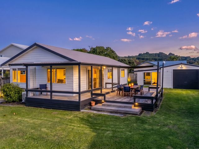 A house with a deck and outdoor furniture at Nest by the Beach - Cooks Beach