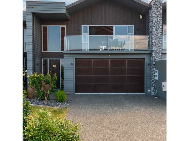 A house exterior with a garage door and balcony at Lake View Bliss - Lake Taupo