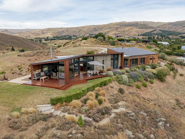 A house with a deck and garden at Vino and Views - Bannockburn Holiday Home Cromwell