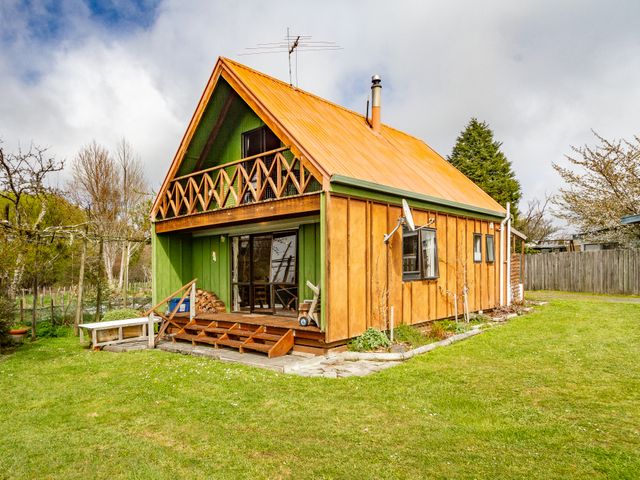 A wooden house with orange roof and green walls with a small porch and balcony at Green Gables - Raetihi Holiday Home in Raetihi