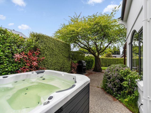 A hot tub next to a grill and tree at Kokomea House - Wanaka