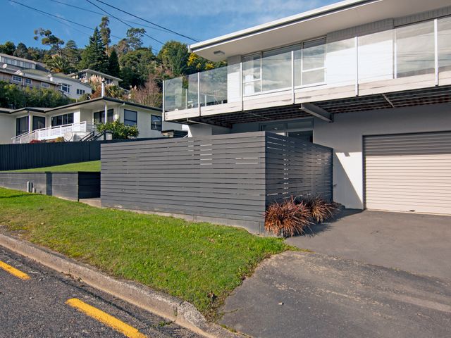 A residential street with modern houses grass and a wooden fence at Sounds Studio - Picton Downstairs Unit in Picton