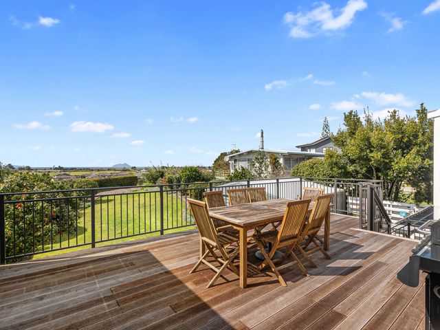 An outdoor dining area with a table and chairs at Family Tides - Ruakaka Holiday Home in Ruakaka
