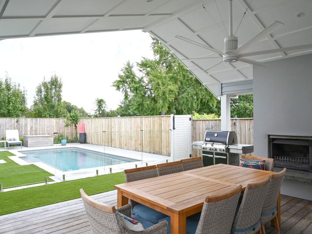 An outdoor dining area with a table and chairs near a swimming pool at Modern Deluxe - Havelock North Holiday Home Havelock North