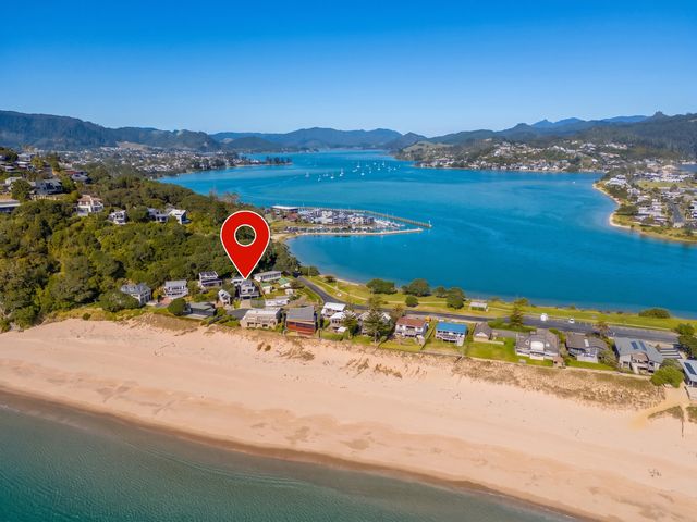 An aerial view of a beach with houses and coastline at Ocean View Beach Beauty - Tairua
