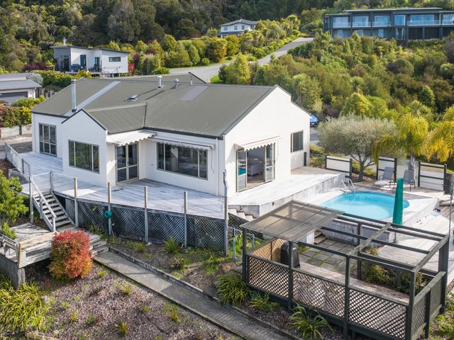 A house with a wooden deck and a small swimming pool surrounded by trees at Vista Del Escape - Riwaka Holiday Home in Riwaka
