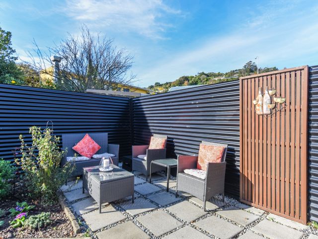 An outdoor seating area with chairs and a table at Tahunanui Shoreside - Nelson Holiday Home Tahunanui Beach