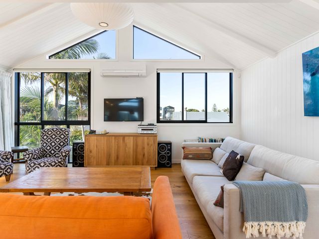 A living room with a sofa and television at Waihi Beach Holiday Home in Waihi Beach