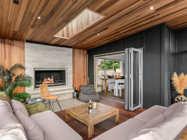 A living room with a fireplace and sofa at Sweet Seabreeze - Mangawhai Heads Holiday Home, Mangawhai