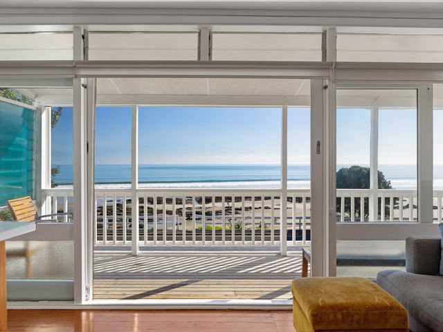 A living room with a view of the ocean and beach at Ahipara in Kaitaia