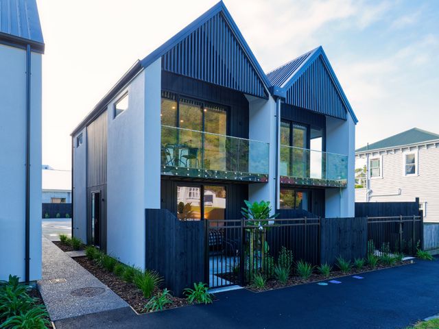 A modern building with balconies and a pathway at Ocean Whisper Retreat - Kaikoura