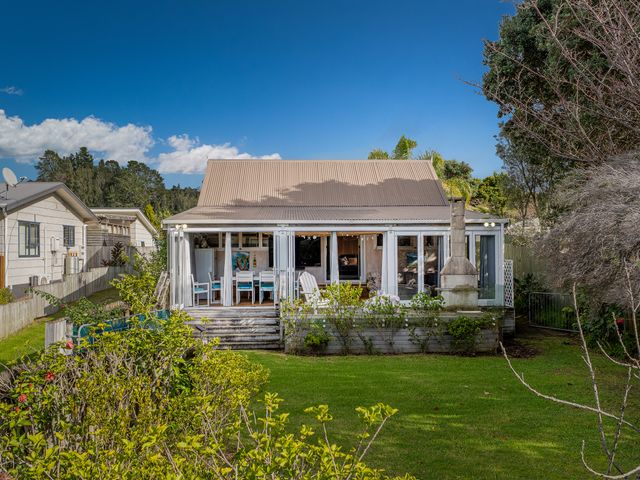 A house with a deck and garden at Home Away From Home In Whangamata