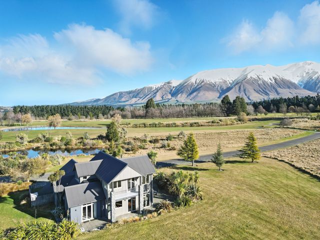 An outdoor view of a house with mountains in the background at The Alpine Edge - Windwhistle Holiday Home in Canterbury