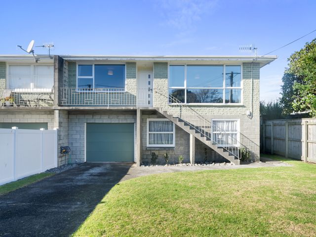 A house with a balcony and garage at The Beach Base - Paraparaumu Holiday home Paraparaumu