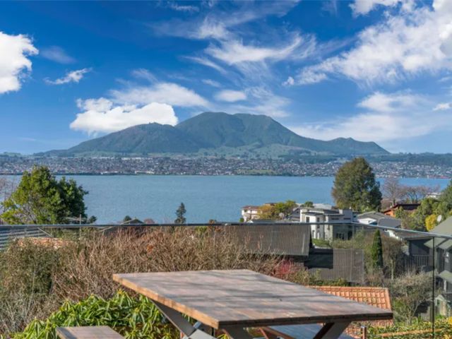 A view of a lake and mountain from a patio at Acacia Horizons - Taupo Holiday Home Acacia Bay