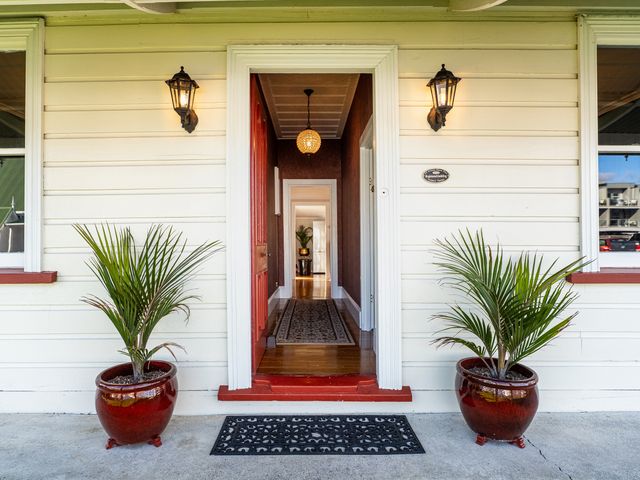 A doorway with potted plants and a lantern at Creed Cottage - Whitianga Holiday Home Whitianga